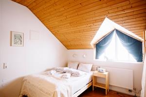 Family room with private bathroom, double bed and bunk beds. 