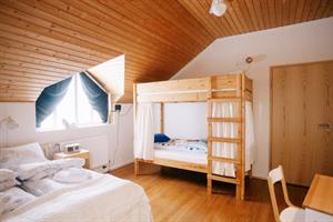 Family room with private bathroom, double bed and bunk beds. 
